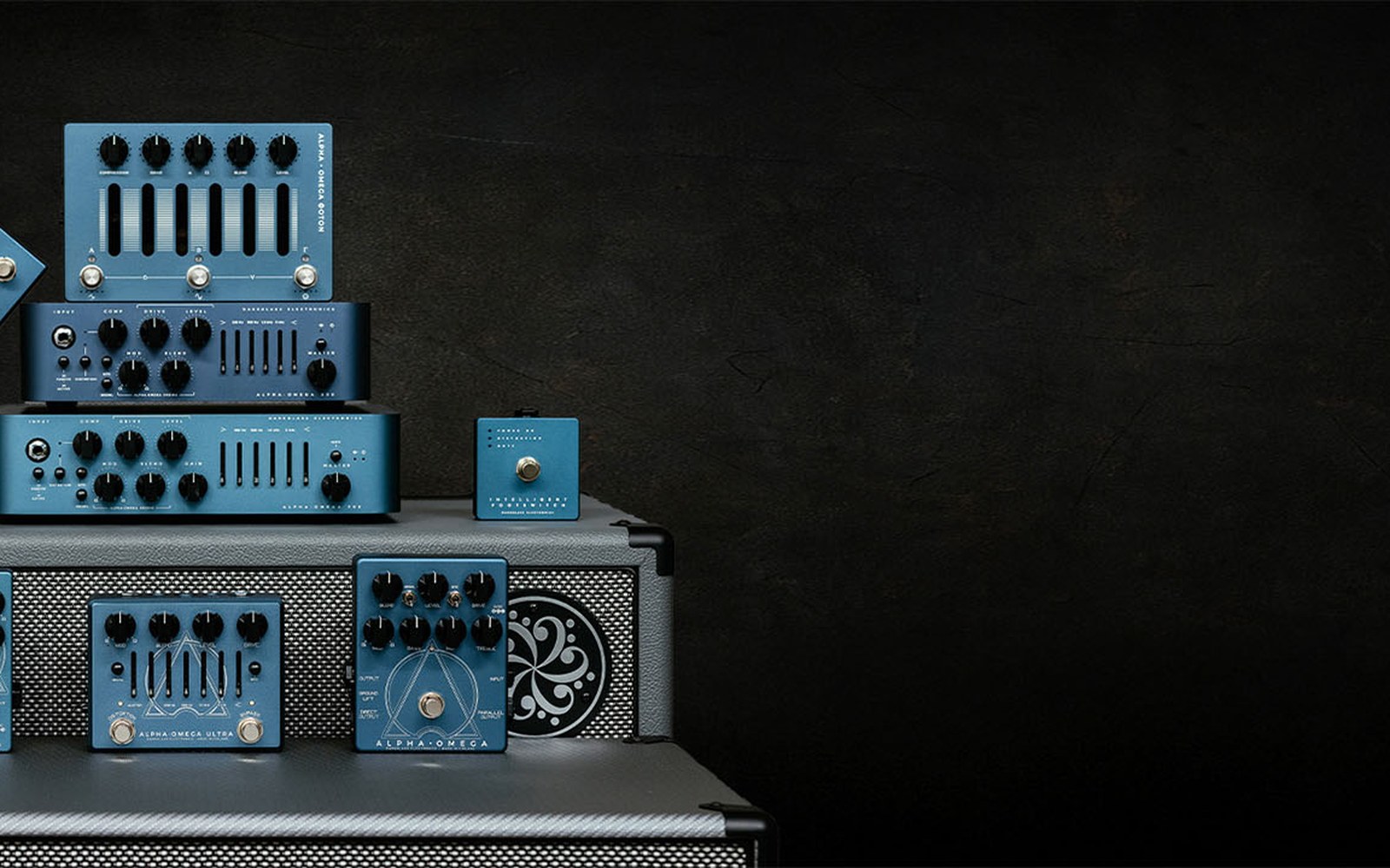 Stacked blue bass preamp pedals and amp heads arranged on a speaker cabinet