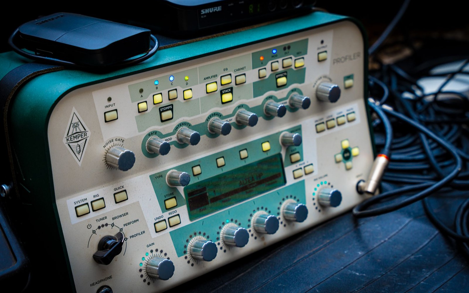 Kemper Profiler amp head with illuminated knobs and buttons on a stage floor