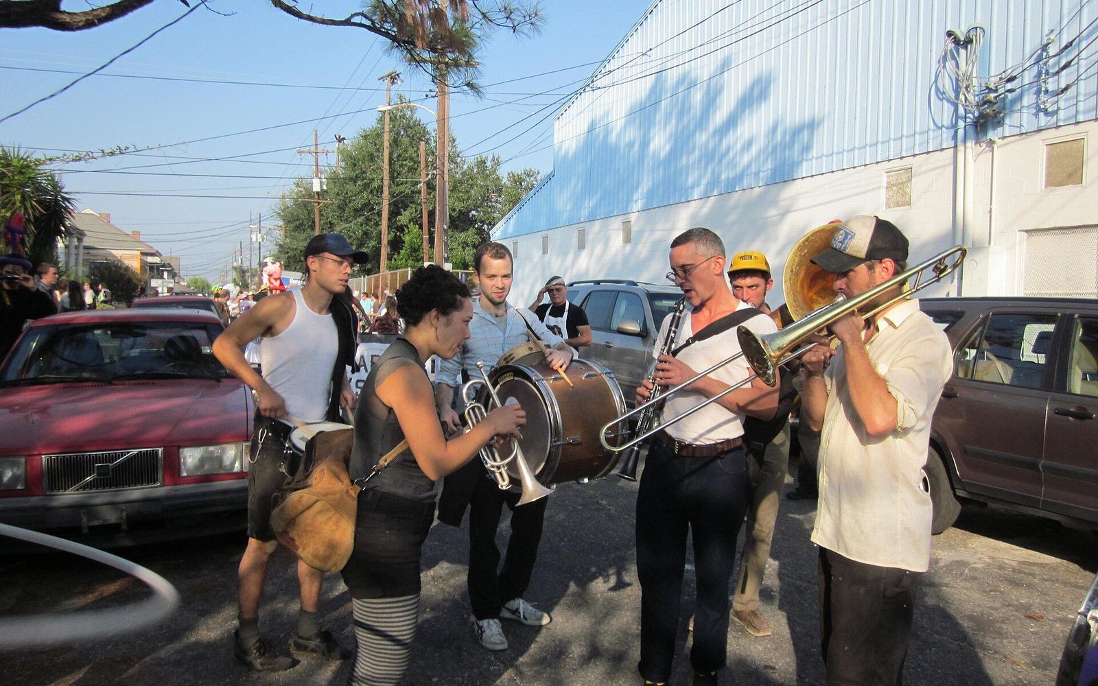 Brass band musicians play trombone, trumpet, clarinet and tuba on a residential street